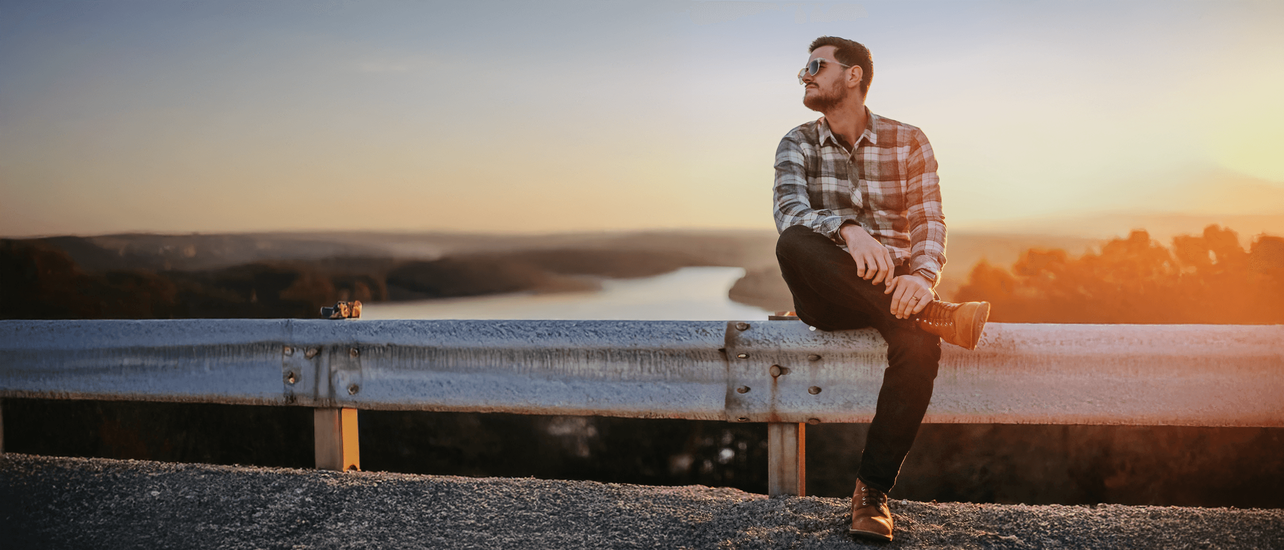 James Gurtner sitting on a guardrail at sunset overlooking the Tennessee River near Chattanooga.